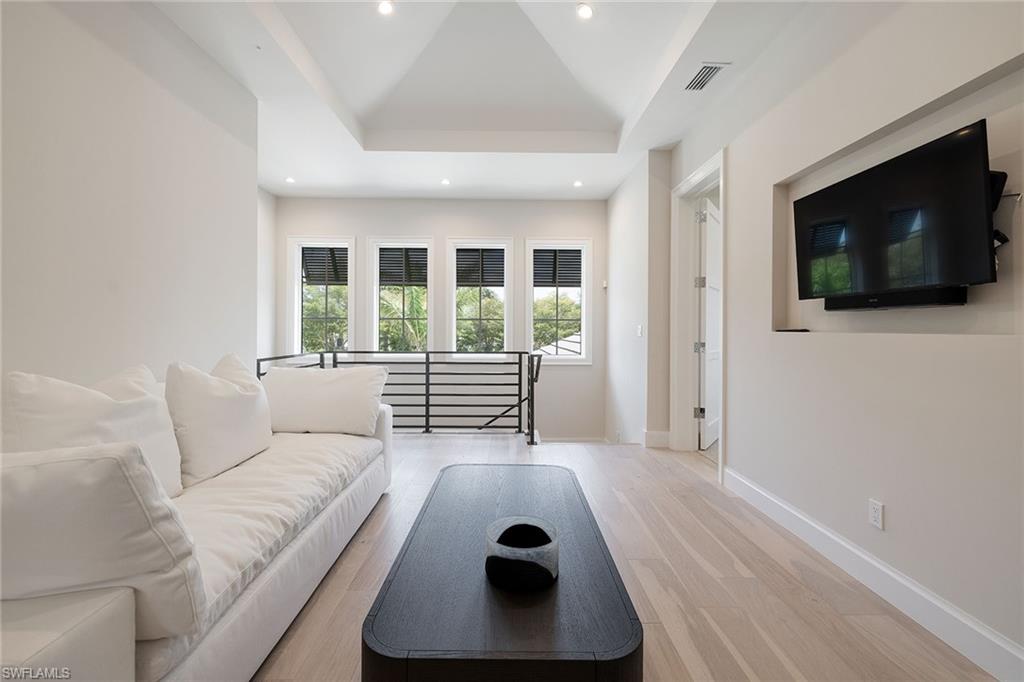 16776 Enclave Circle Naples, FL 34110 - Photo 15 of 50 a living room with a flat screen tv and a fireplace