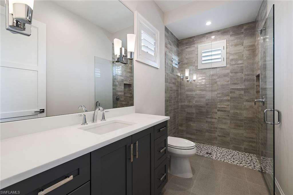 16776 Enclave Circle Naples, FL 34110 - Photo 17 of 50 a bathroom with a sink a toilet and shower