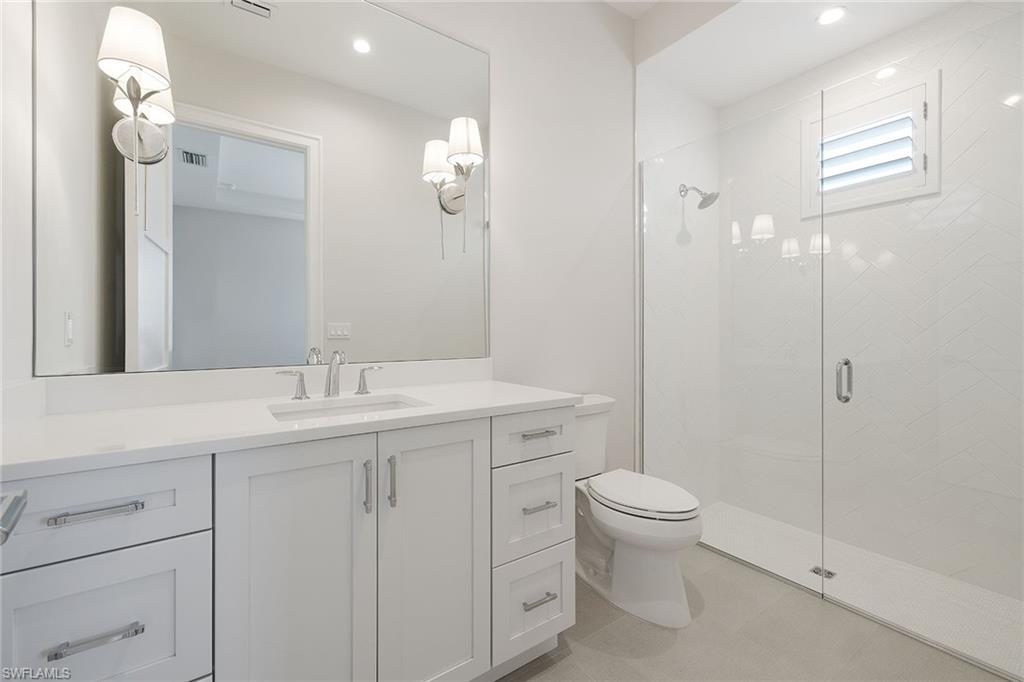 16776 Enclave Circle Naples, FL 34110 - Photo 20 of 50 a bathroom with a toilet a sink a mirror a vanity and shower