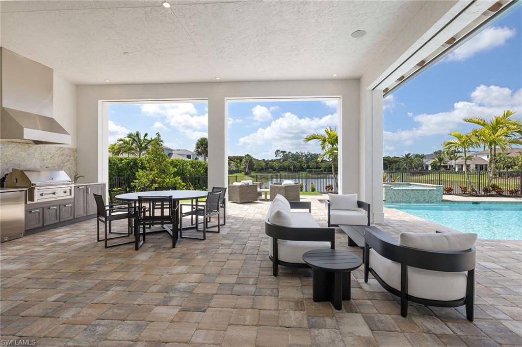 16776 Enclave Circle Naples, FL 34110 - Photo 29 of 50 a living room with patio furniture and a floor to ceiling window