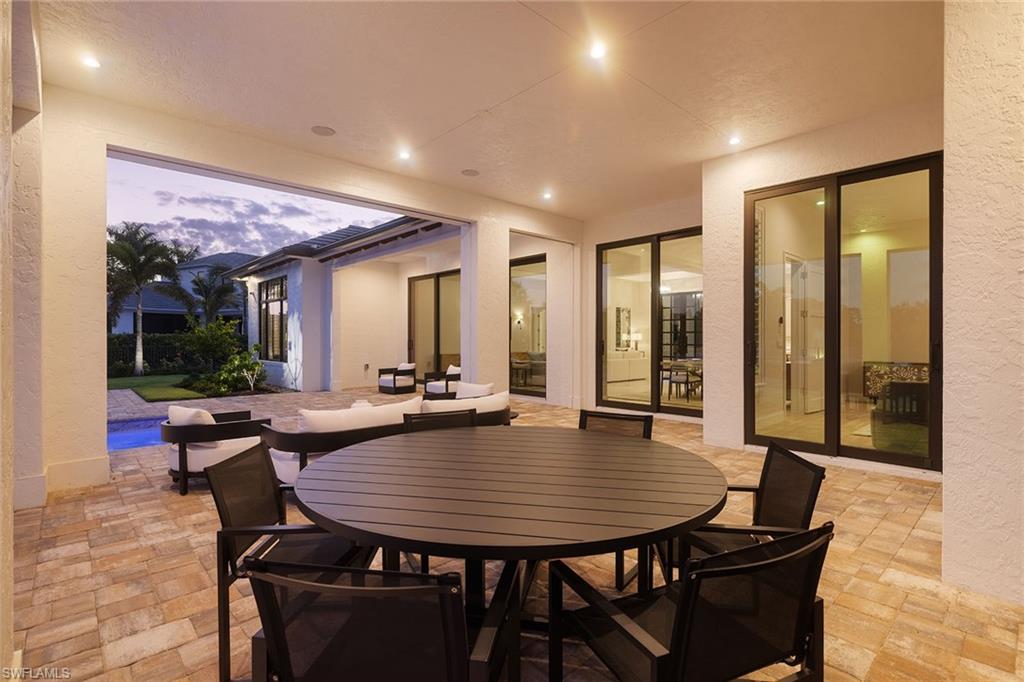 16776 Enclave Circle Naples, FL 34110 - Photo 38 of 50 a view of a dining room and livingroom with furniture wooden floor and a rug