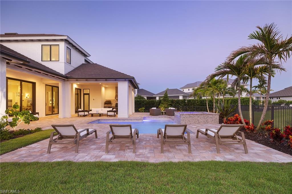 16776 Enclave Circle Naples, FL 34110 - Photo 39 of 50 a view of a patio with table and chairs potted plants and a palm tree