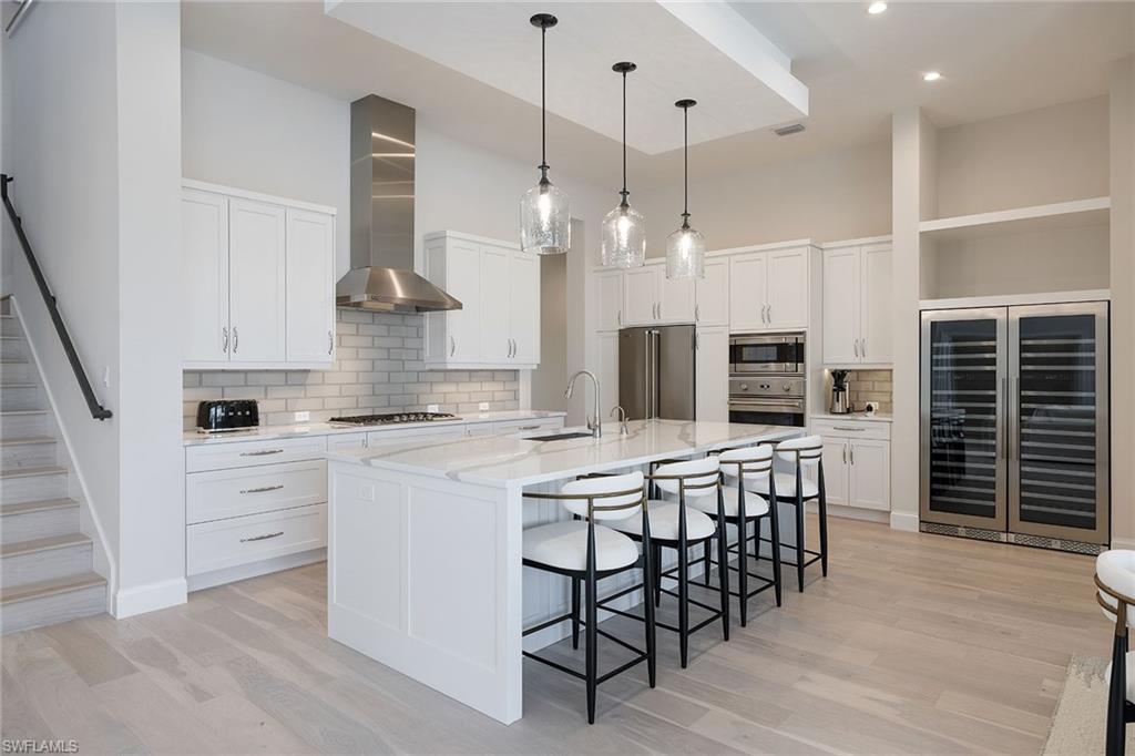 16776 Enclave Circle Naples, FL 34110 - Photo 8 of 50 a kitchen with stainless steel appliances kitchen island granite countertop a table chairs sink and cabinets