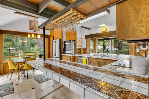 a kitchen with stainless steel appliances granite countertop a stove and white cabinets with wooden floor