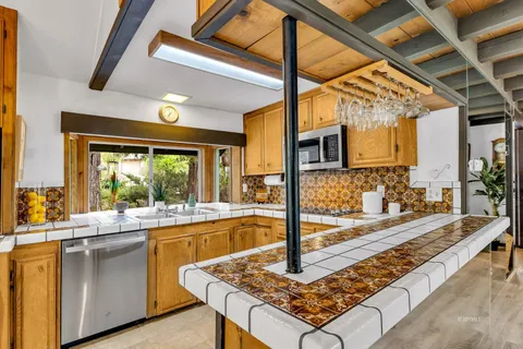 a kitchen with stainless steel appliances a stove a sink cabinets and dining table
