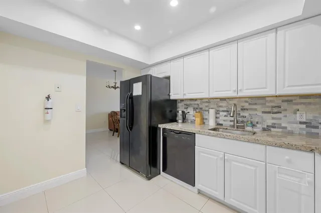 a kitchen with a refrigerator sink and cabinets