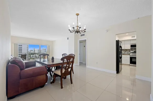 a living room with furniture a chandelier and a dining table