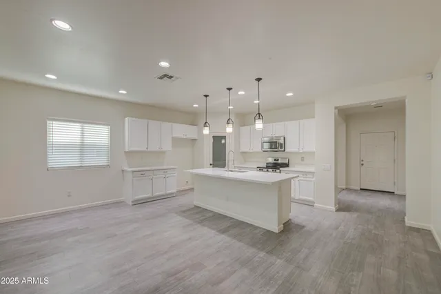 a large white kitchen with a stove a sink dishwasher and a oven with white cabinets