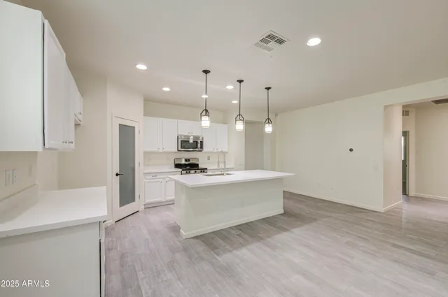 a view of kitchen with kitchen island stainless steel appliances sink refrigerator and microwave