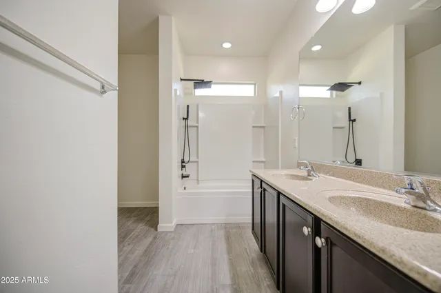 a bathroom with a granite countertop sink mirror and a bathtub