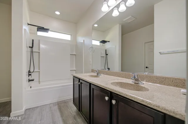 a bathroom with a granite countertop sink a large mirror and a bathtub