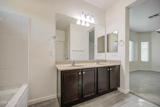 a bathroom with a granite countertop sink a large mirror and a shower