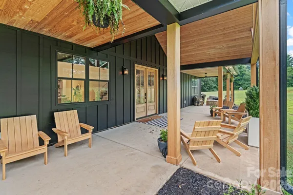 a kitchen with stainless steel appliances kitchen island granite countertop a table chairs and a wooden floor