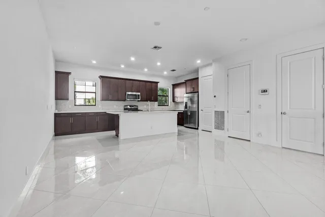 a view of a kitchen with refrigerator and windows