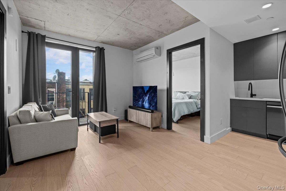 458 East 25th Street, Unit 305 Brooklyn, NY 11226 - Photo 6 of 14 a living room with furniture and a flat screen tv