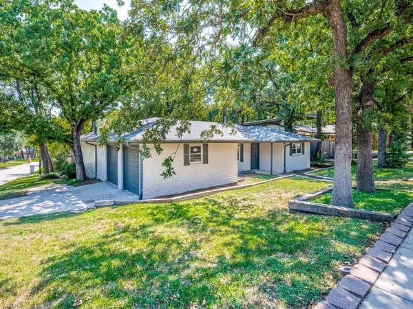 a front view of a house with yard and green space