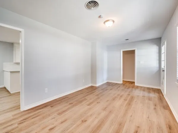 a view of empty room with wooden floor
