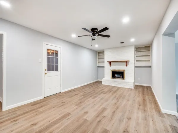 a view of empty room with a fireplace and wooden floor