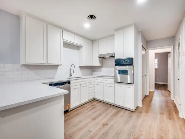 a kitchen with granite countertop white cabinets and white appliances