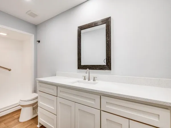 a bathroom with a toilet sink and mirror
