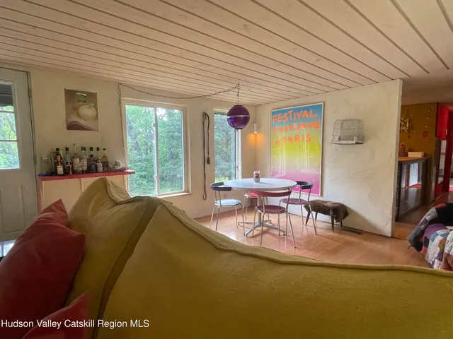 a living room with furniture a flat screen tv and a large window