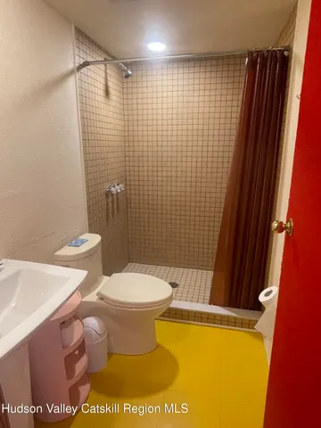 a bathroom with a toilet and a shower