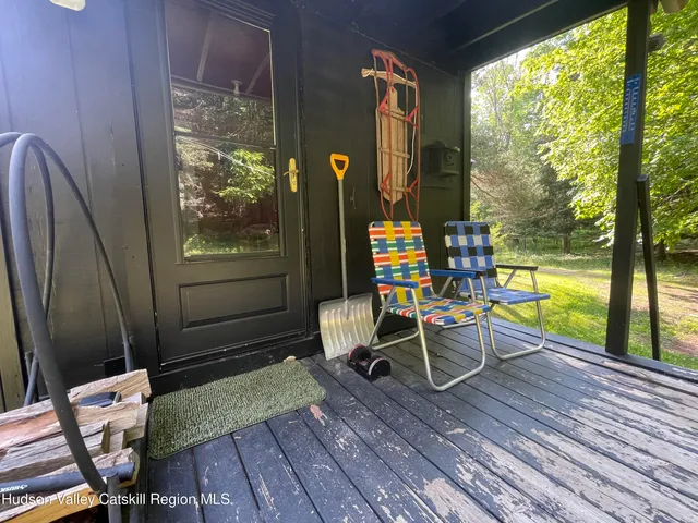 a view of a deck with a table chairs and a floor to ceiling window