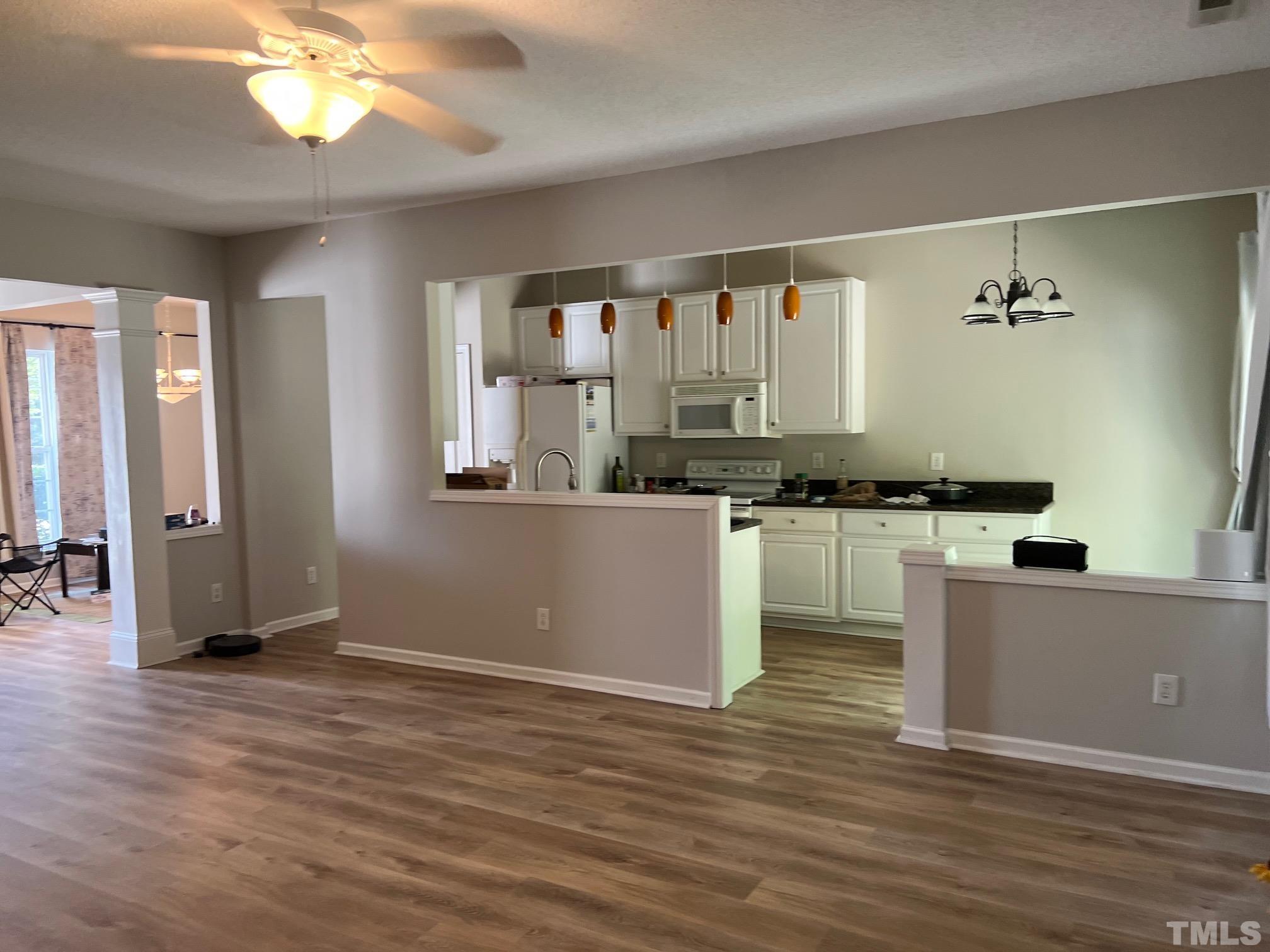 302 Durston Loop Morrisville, NC 27560 - Photo 3 of 21 a kitchen with stainless steel appliances kitchen island granite countertop a stove a sink and a refrigerator
