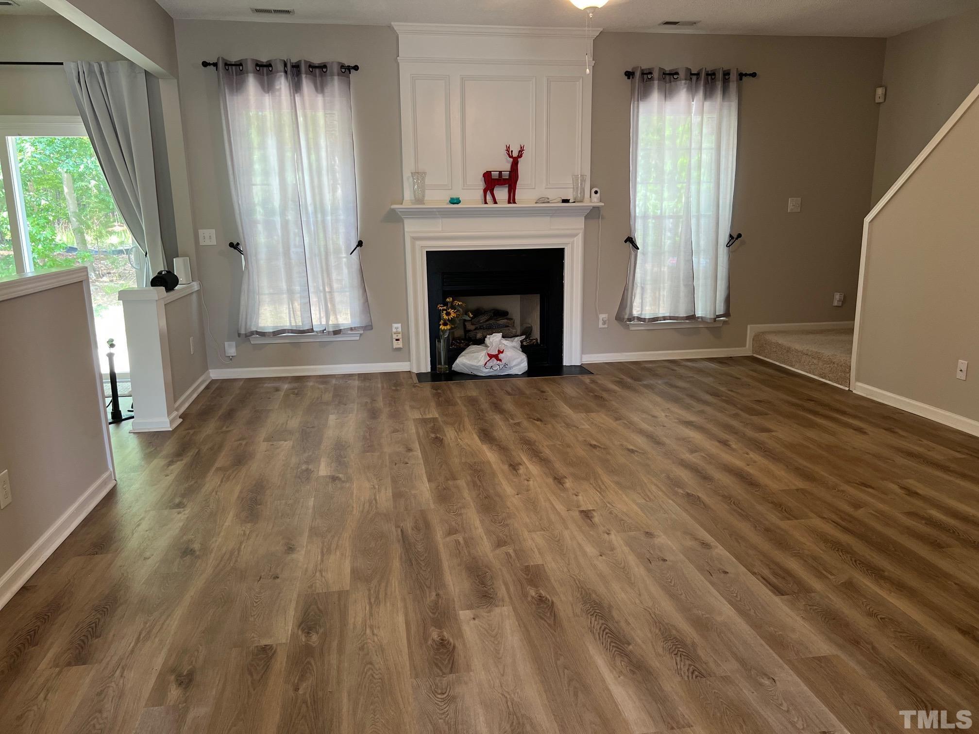302 Durston Loop Morrisville, NC 27560 - Photo 7 of 21 a view of an empty room with wooden floor and a window