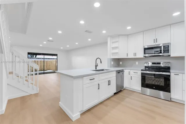 a large kitchen with stainless steel appliances granite countertop a stove and a sink
