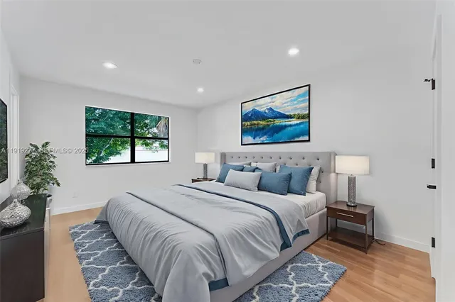 a bedroom with a large bed and a painting on the wall