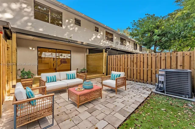 a patio with patio a couch and wooden fence