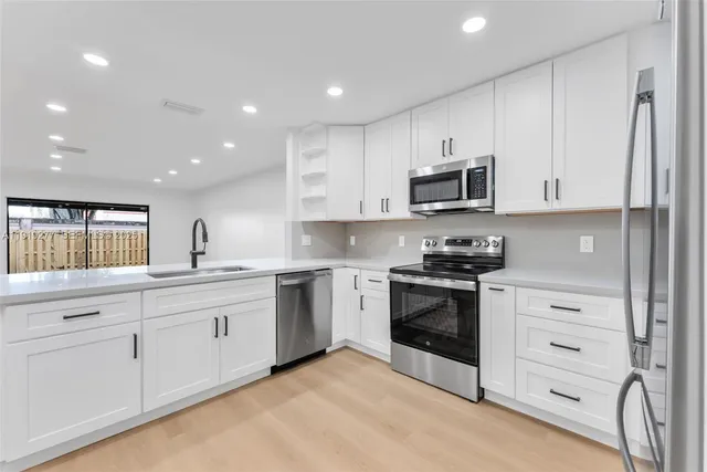 a kitchen with stainless steel appliances granite countertop a stove and a sink
