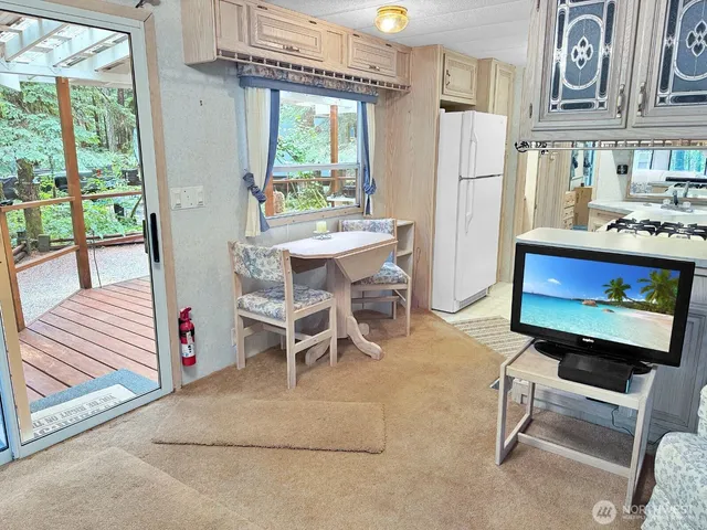 a outdoor dining space with furniture a large window and stainless steel appliances