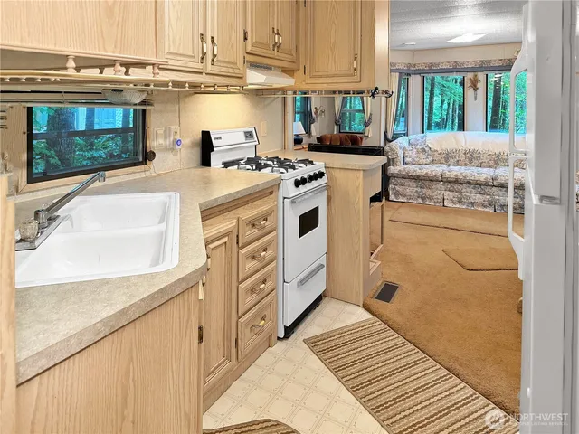 a kitchen with stainless steel appliances a stove a sink and a microwave
