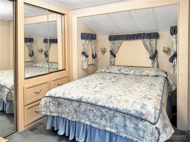 a bed sitting in a bedroom next to a window