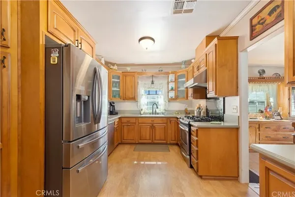 a kitchen with stainless steel appliances granite countertop a refrigerator a stove and a sink