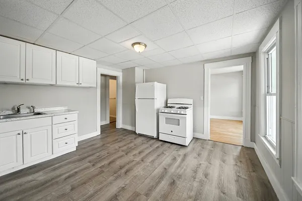 a kitchen with cabinets and wooden floor
