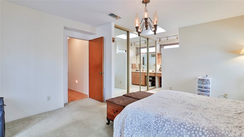 1102 Eucalyptus Drive El Cajon, CA 92020 - Photo 25 of 63 a bedroom with a large bed chandelier and a window
