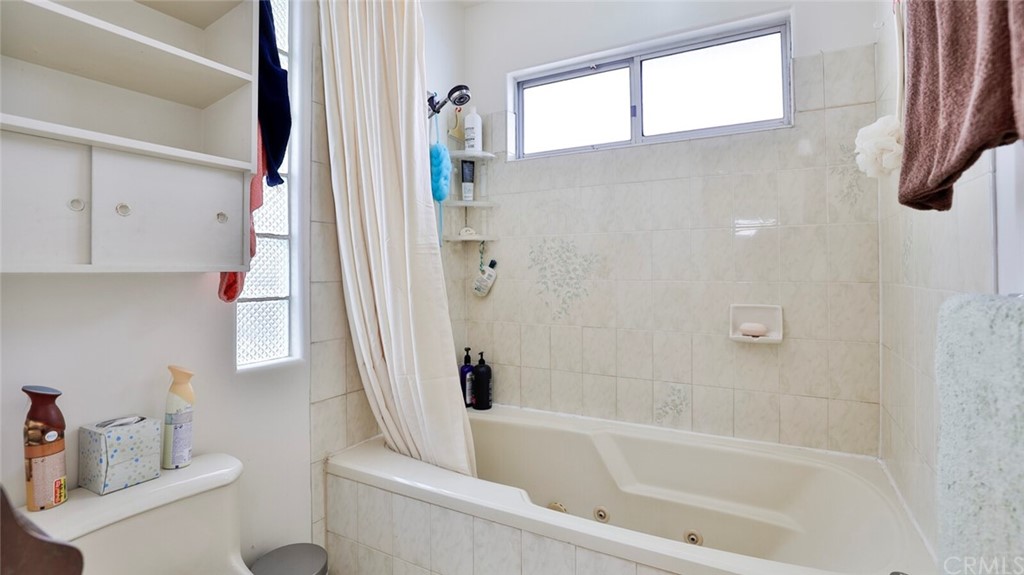 1102 Eucalyptus Drive El Cajon, CA 92020 - Photo 27 of 63 a bathroom with a bathtub a window a sink and a toilet