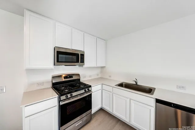 a kitchen with a sink and a stove top oven