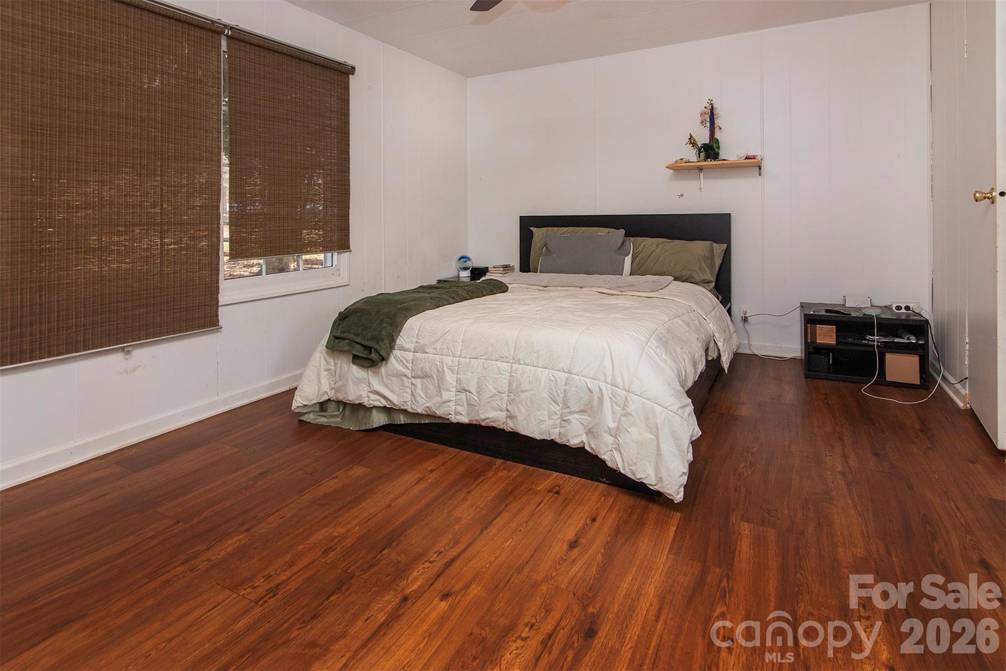 5727 Thompson Road Charlotte, NC 28216 - Photo 12 of 21 a bedroom with a bed and wooden floor