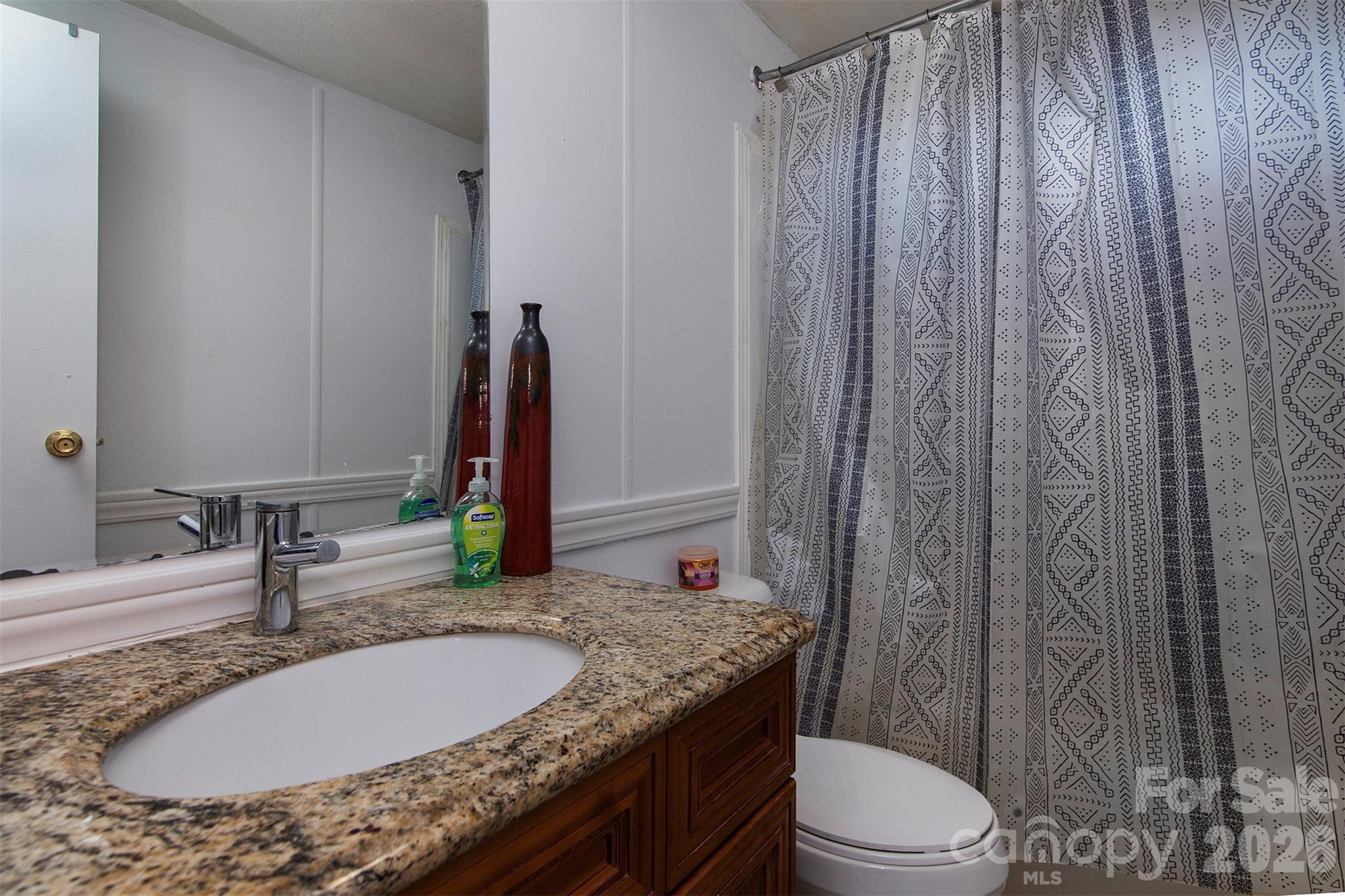 5727 Thompson Road Charlotte, NC 28216 - Photo 15 of 21 a bathroom with a granite countertop sink and a mirror