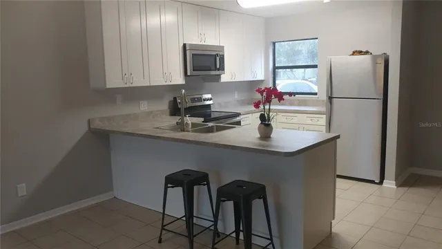 a kitchen with stainless steel appliances granite countertop a sink refrigerator and microwave