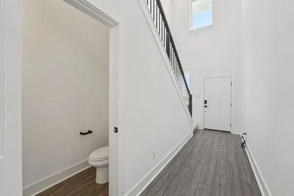 a bathroom with a toilet and a wooden floor