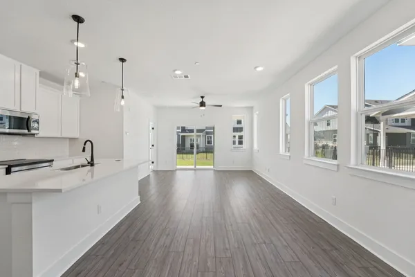 a large kitchen with stainless steel appliances a large window a oven a sink and a chandelier