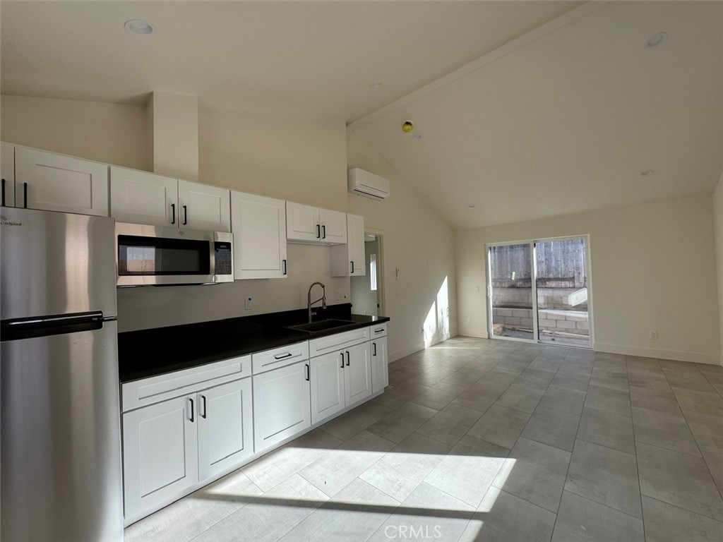 921 Regal Road Encinitas, CA 92024 - Photo 19 of 23 a kitchen with granite countertop a refrigerator and a stove top oven
