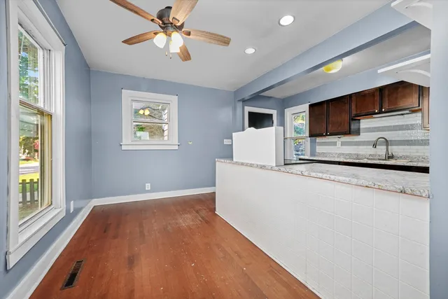 a kitchen with stainless steel appliances granite countertop a sink a stove a refrigerator cabinets and wooden floor