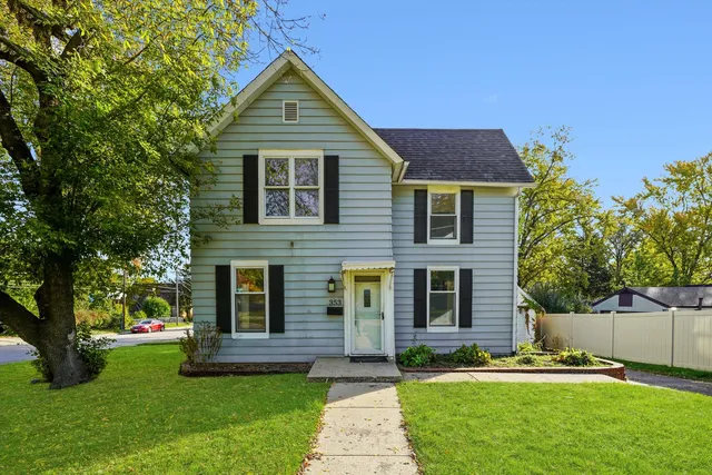 a front view of a house with a yard and trees