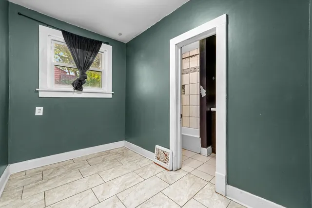 a view of an empty room with window and bathroom